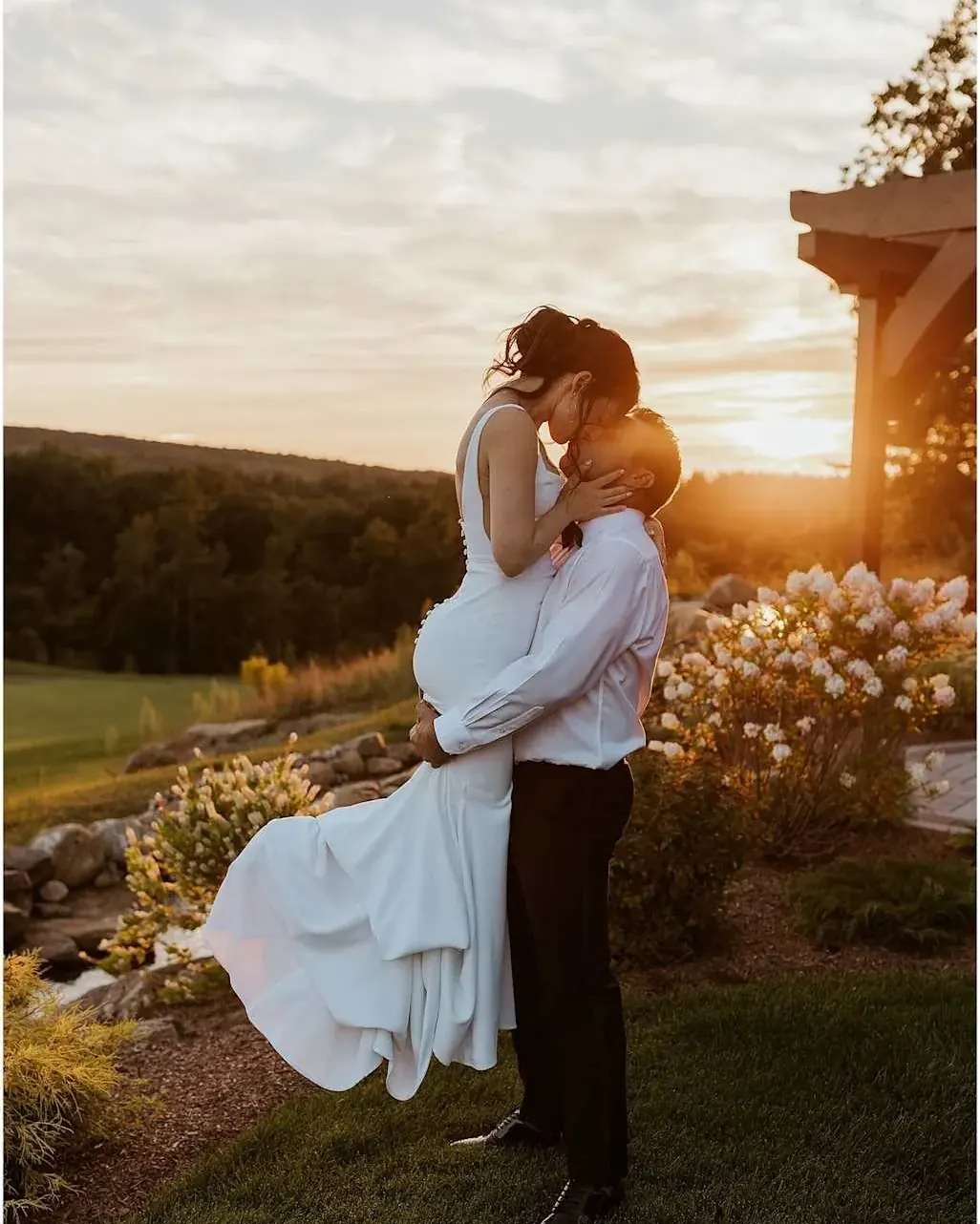 Sposi abbracciati al tramonto, sposa in dolce attesa